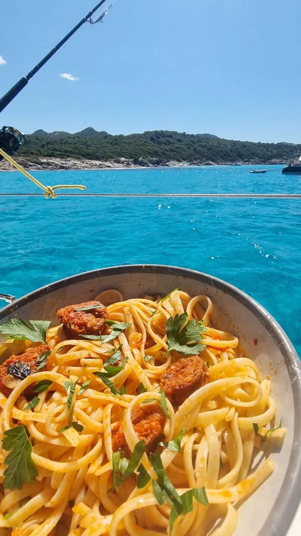 Assiette de pâtes à la tomate servie à bord du voilier