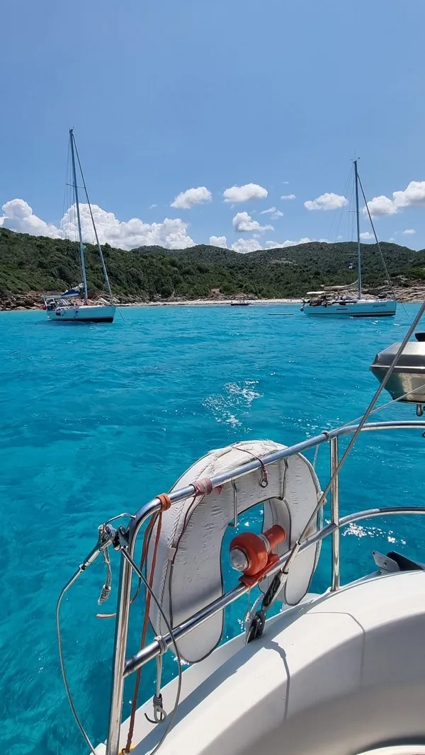 Deux voiliers au mouillage dans une anse aux eaux cristallines du désert des Agriates