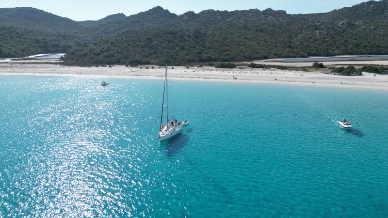 Voilier Eridu au mouillage devant la plage de Saleccia dans le désert des Agriates, eau turquoise cristalline
